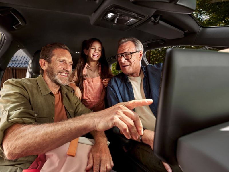 Interior of a VW vehicle with 3 people sat inside. 