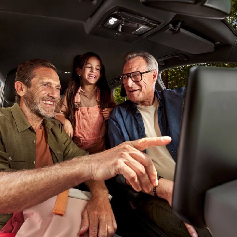 Interior of a VW vehicle with 3 people sat inside. 