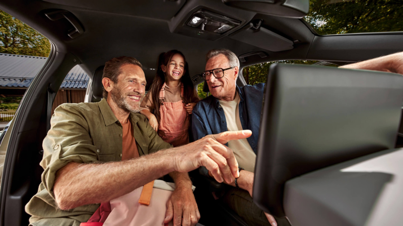 Interior of a VW vehicle with 3 people sat inside. 