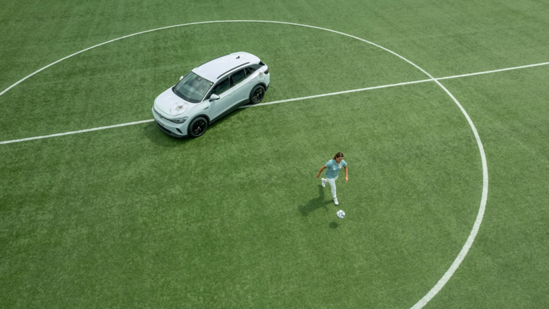 Inka Grings joue au football sur un terrain de football à côté de son ID.4