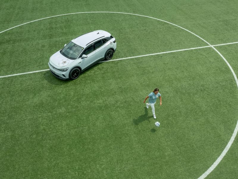 Inka Grings joue au football sur un terrain de football à côté de son ID.4