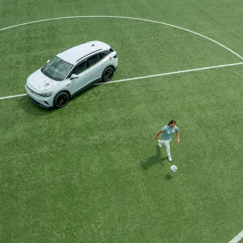 Inka Grings joue au football sur un terrain de football à côté de son ID.4