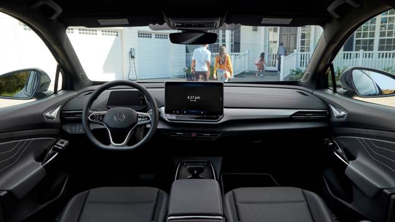 Vue intérieure d'un Volkswagen ID.4 avec une famille visible à l'extérieur.