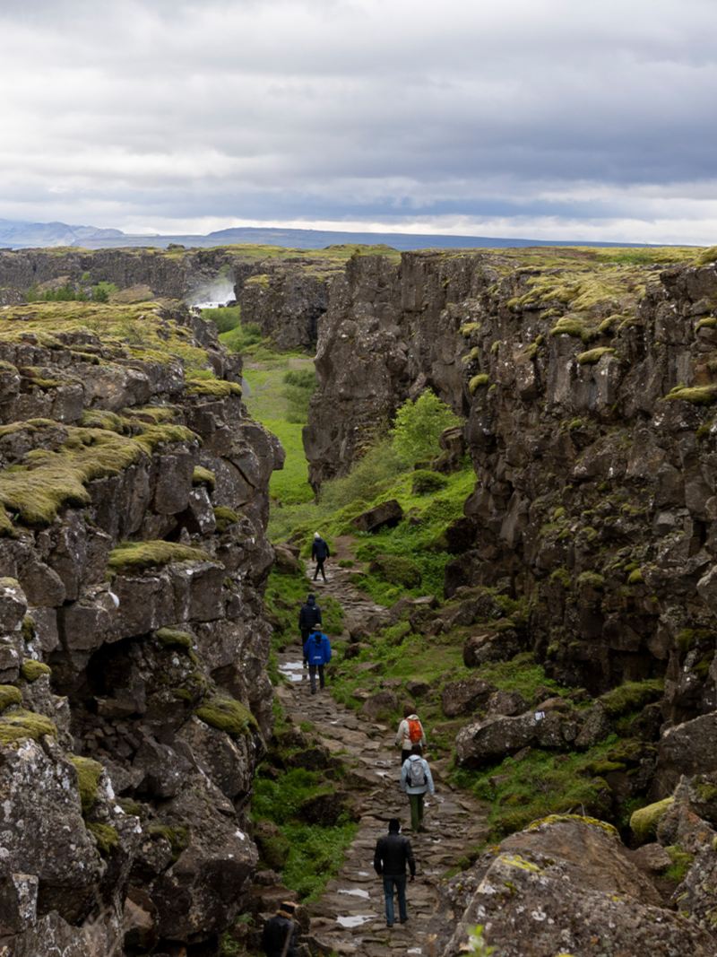 Der Nationalpark Þingvellir mit Touristen, welche durch das Tal laufen
