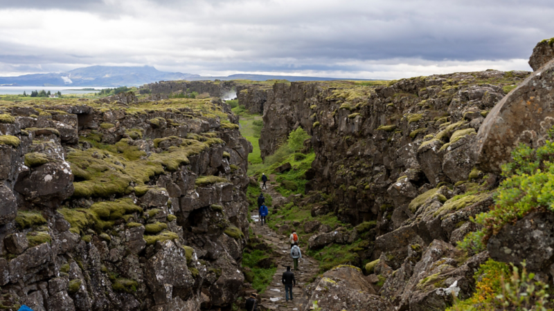 Der Nationalpark Þingvellir mit Touristen, welche durch das Tal laufen