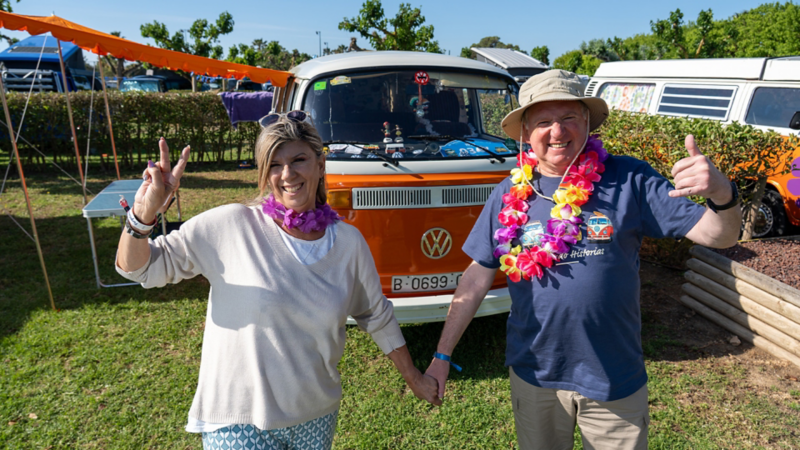 Una mujer y un hombre dándose la mano delante de una VW Clásica.