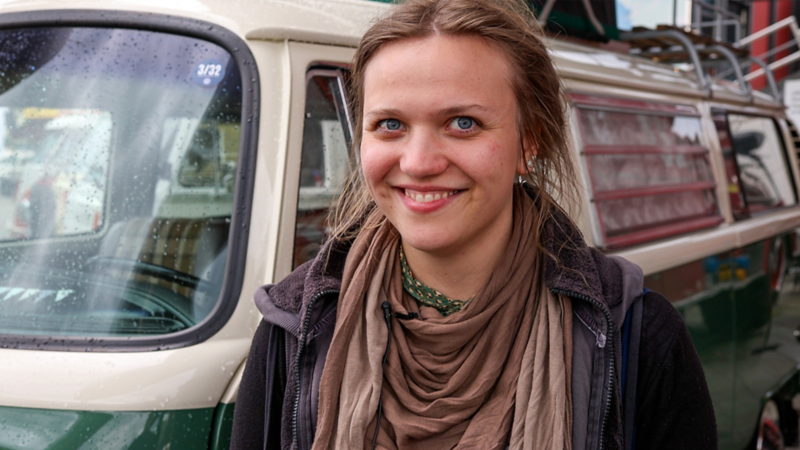 Karin Sterchi steht lächelnd vor ihrem VW T2