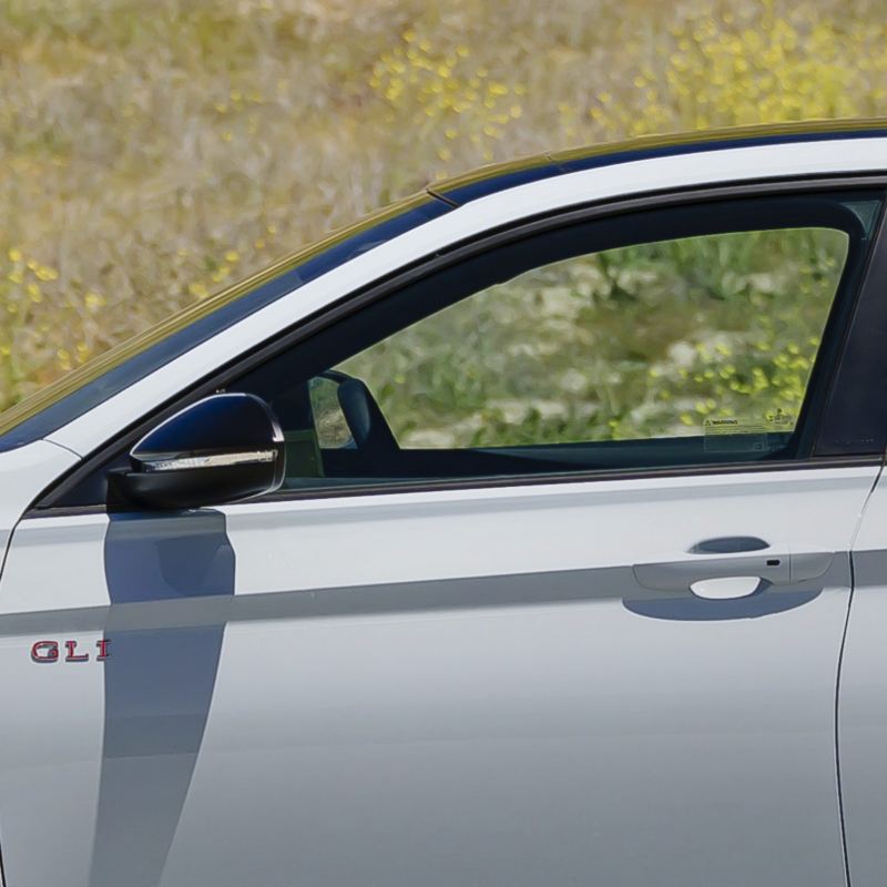 Close-up of the 2025 VW Jetta GLI's driver-side door, highlighting the KESSY keyless access feature with a push-start button.