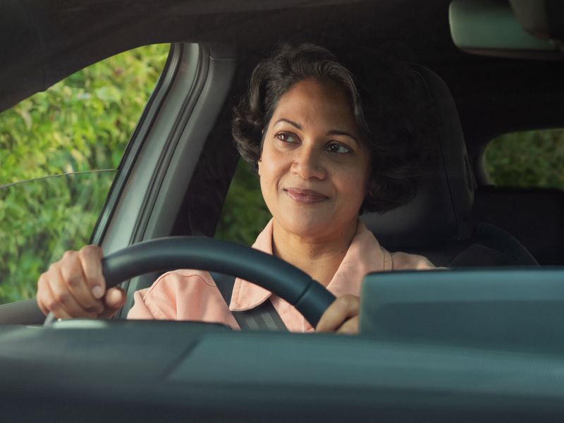 Interior close-up of person driving a VW vehicle