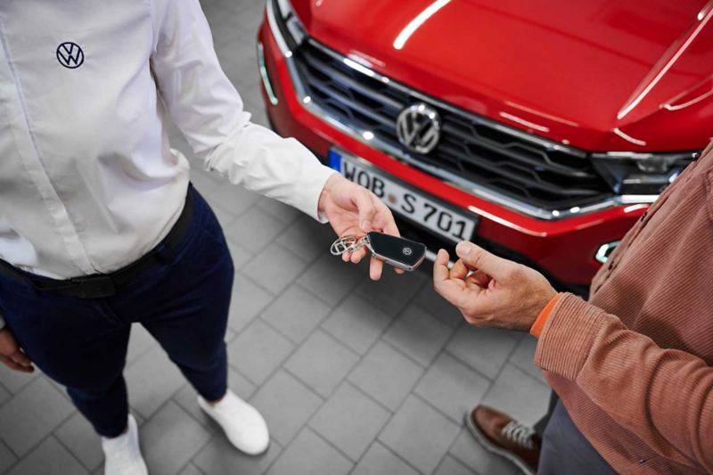 Un consulente Volkswagen consegna la chiave a un cliente.