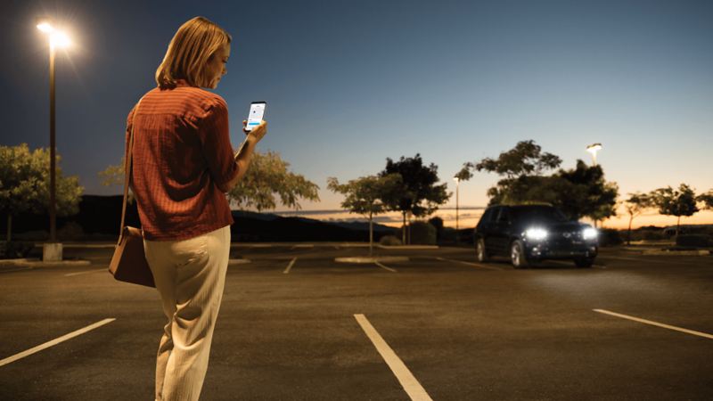 Woman in parking lot using the location services feature on the Car-Net® app