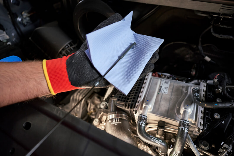 Un employé de Volkswagen verse du liquide de refroidissement dans une voiture Volkswagen