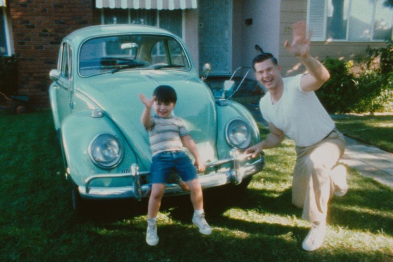 VW vintage coccinelle un fils et son père dans leur jardin