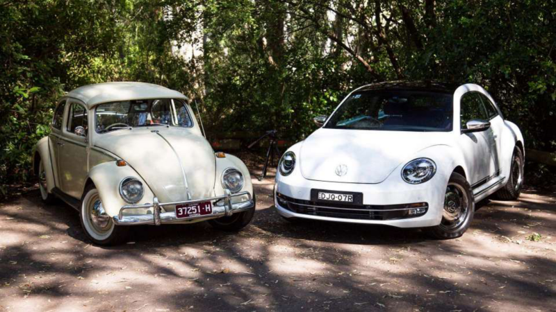 A vintage VW Beetle next to a modern day Beetle