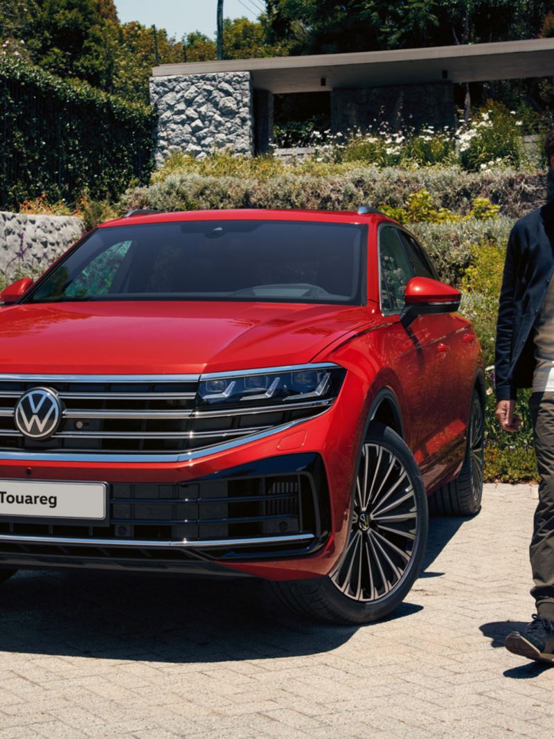 The new 2024 VW Touareg being parked at a house, a man walks in front of it.