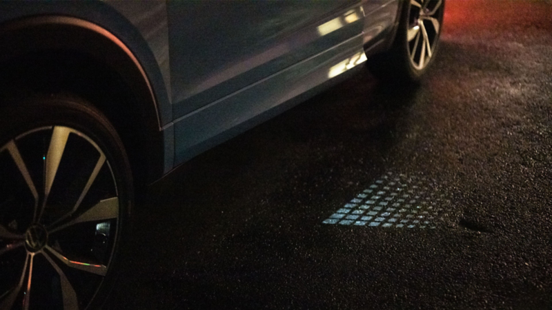 The driver’s door from above, only a crack open, with light projecting visibly in the twilight.