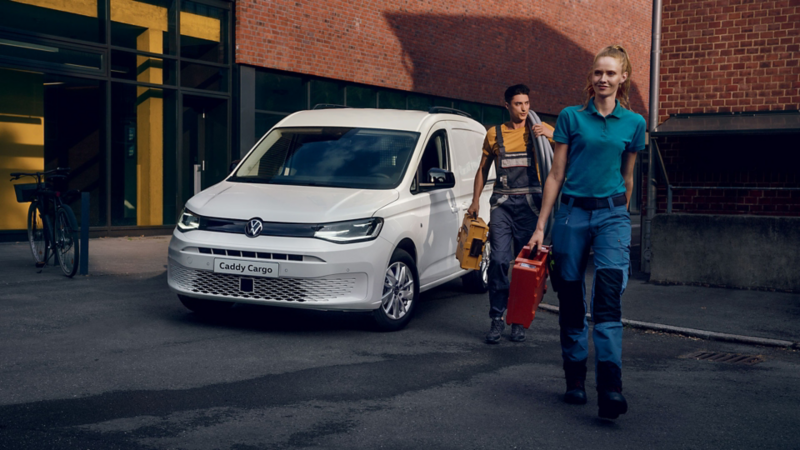 Due operai si allontanano da Nuovo Caddy Cargo Volkswagen, visto 3/4 frontalmente.