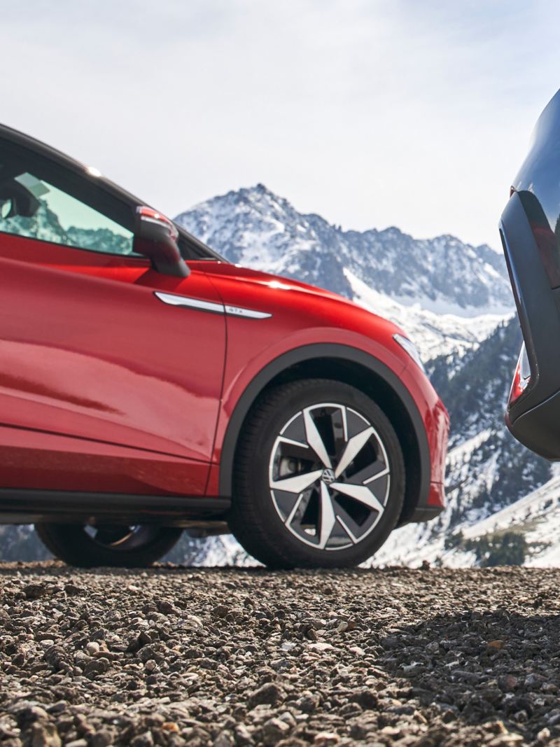 VW ID.5 GTX steht vor anderem VW Auto, im Hintergrund verschneite Berglandschaft