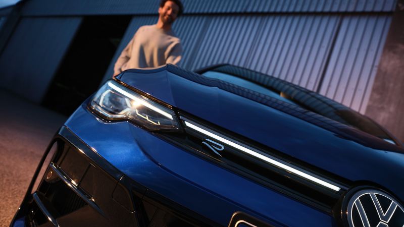 Close-up of the front of a VW Golf R with illuminated LED crossbar