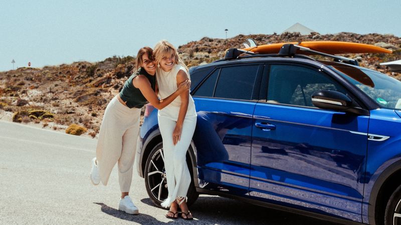 Zwei Frauen stehen neben ihrem VW R T-Roc R in „Lapiz Blue“