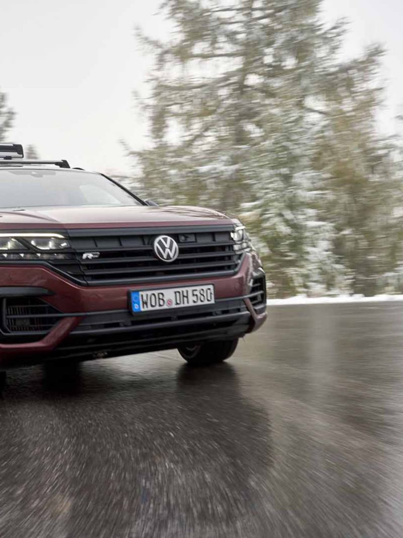 Ripresa angolare di un veicolo Volkswagen mentre cammina su strada bagnata.