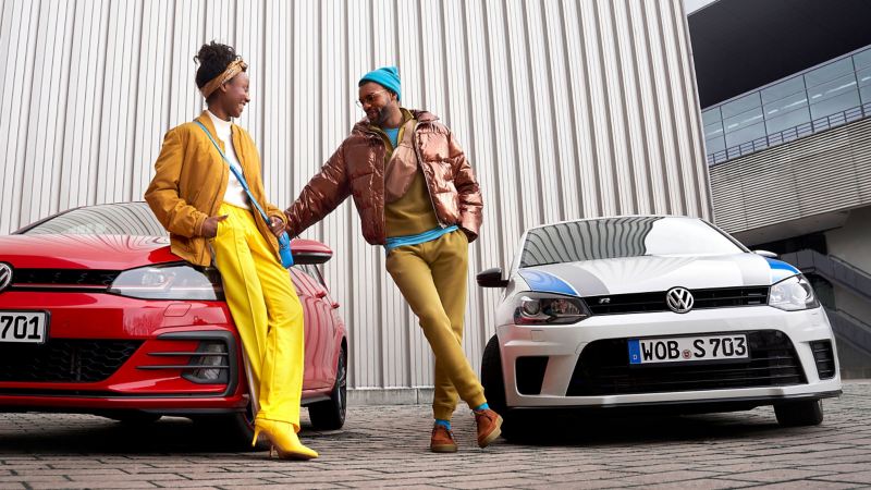 Eine Frau und ein Mann stehen an ihren VW Vorgängermodellen Golf 7 und Polo WRC