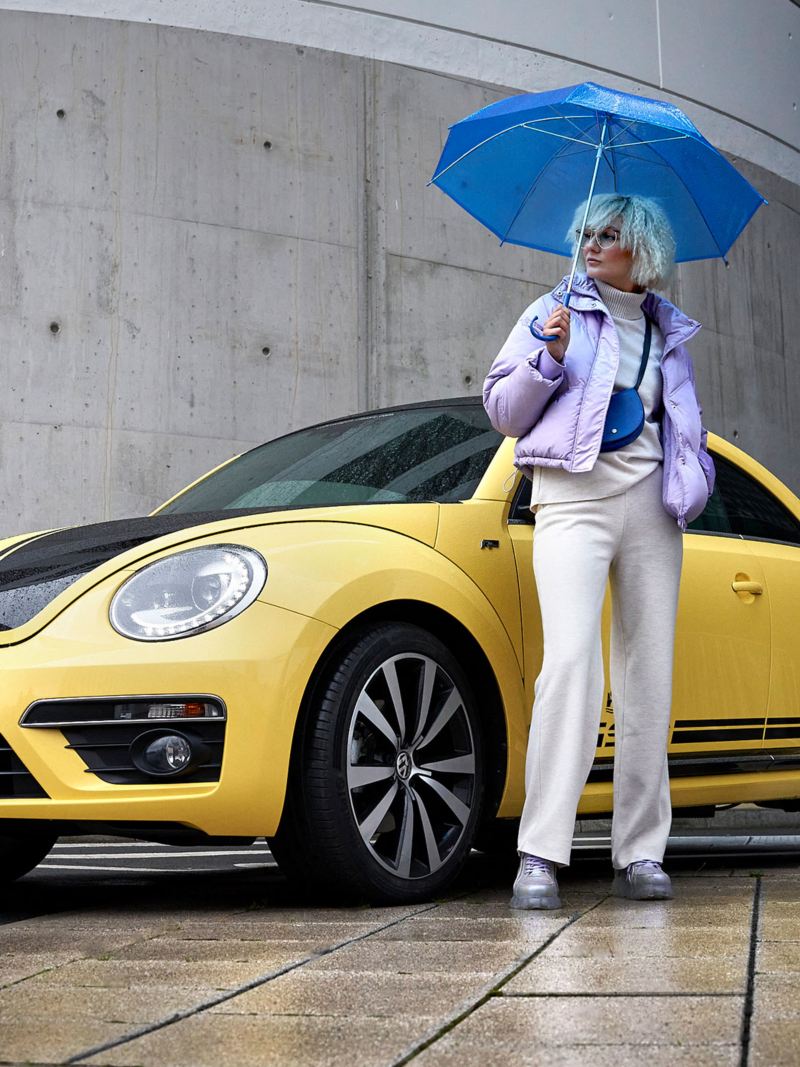 Une femme et sa compacte VW Coccinelle d’occasion