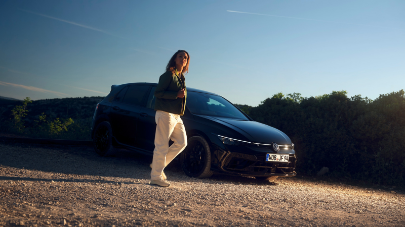 Una donna a fianco di una Nuova Golf R Black Edition.