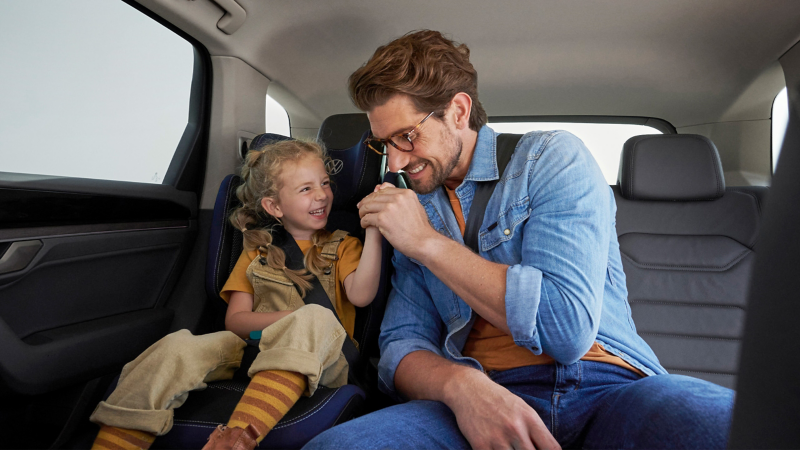 Daughter and father on the back seat of a VW