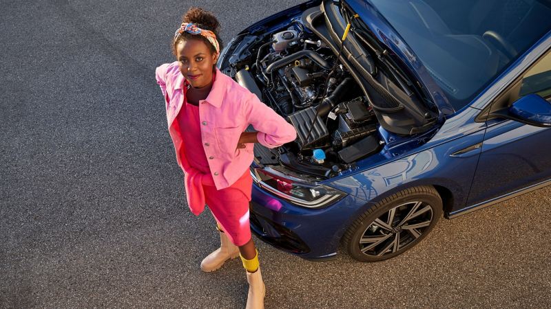 Une femme à côté de sa Volkswagen avec le capot ouvert