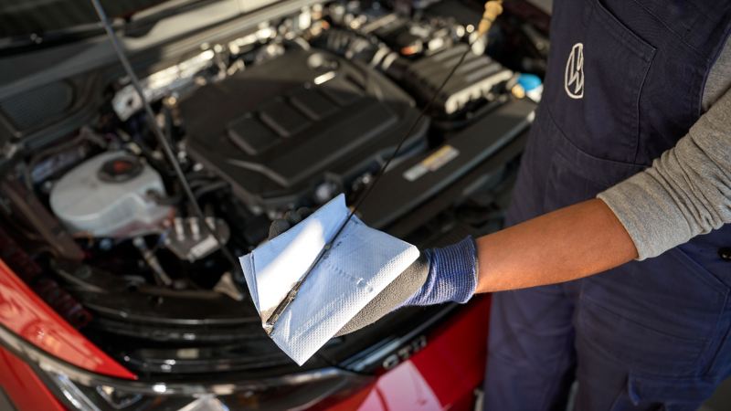 Un collaborateur d’atelier Volkswagen vérifie le niveau d’huile