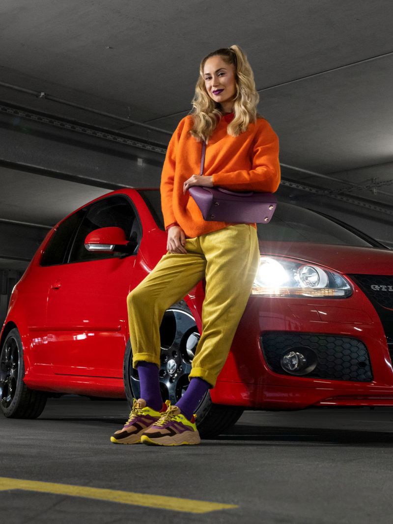 A woman leans against her VW Golf 5 with VW accessories