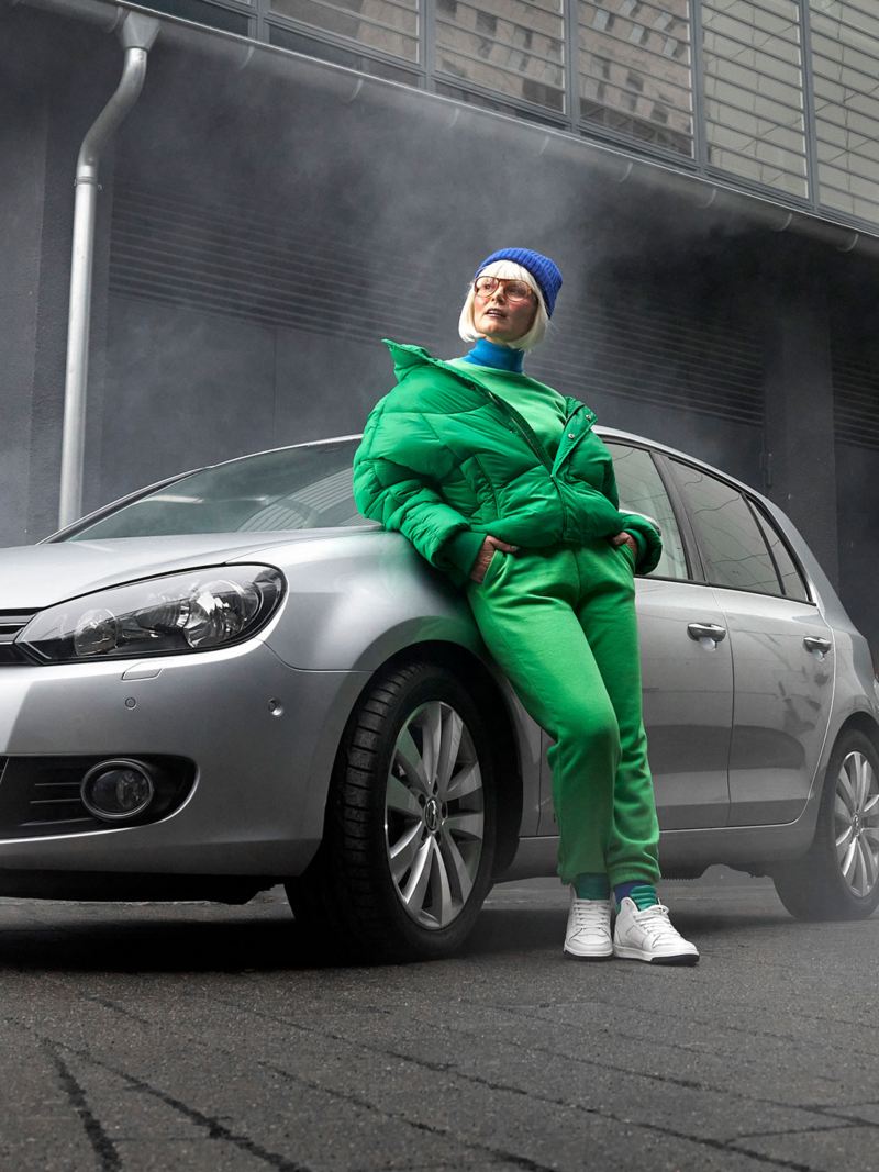 Une femme s’appuyant sur sa VW Golf 6 équipée d’accessoires VW 