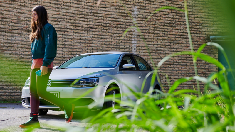 Femme marchant devant un modèle précédent de la VW Jetta 6