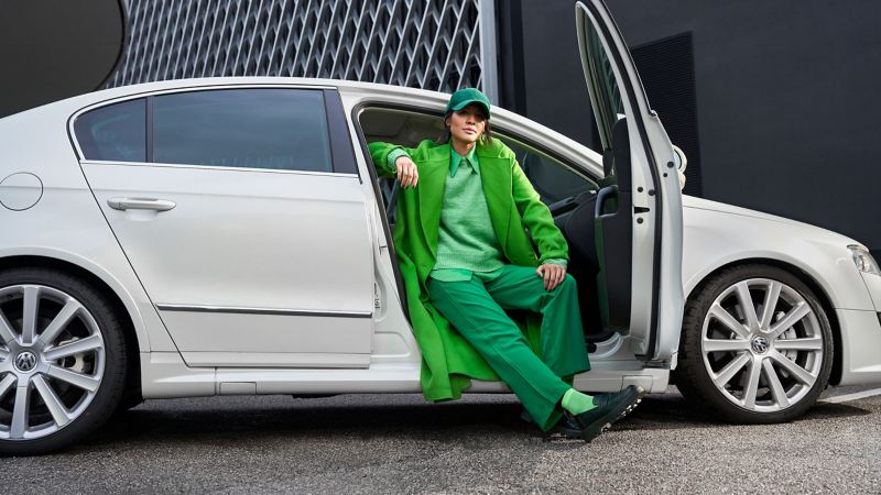 Eine Frau sitzt in ihrem gebrauchten VW Auto der Mittelklasse Passat B6