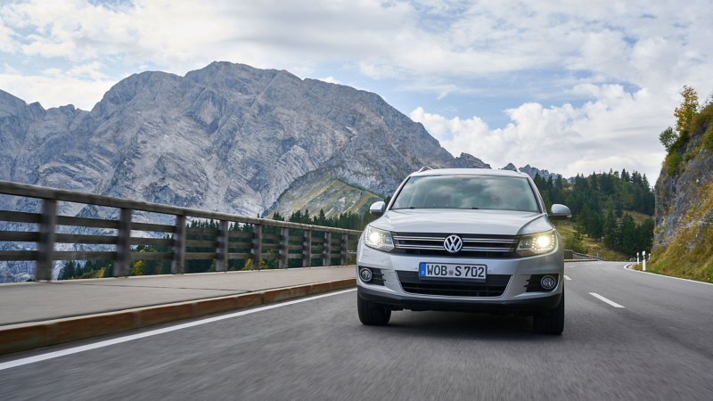 VW Tiguan 1 drives on a mountain road