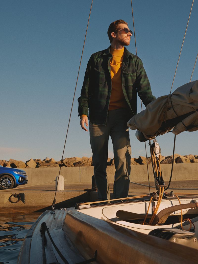 Ein Mann steht auf einem Boot, im Hintergrund parkt der VW T-Roc R