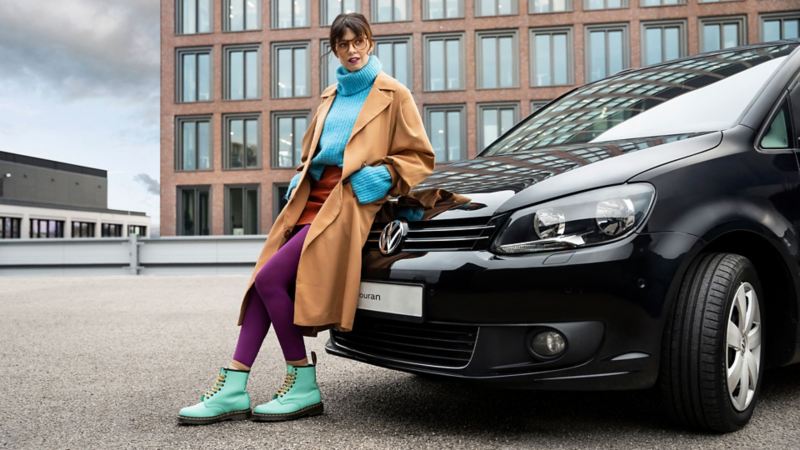 A woman leans against her Touran 1 from Volkswagen