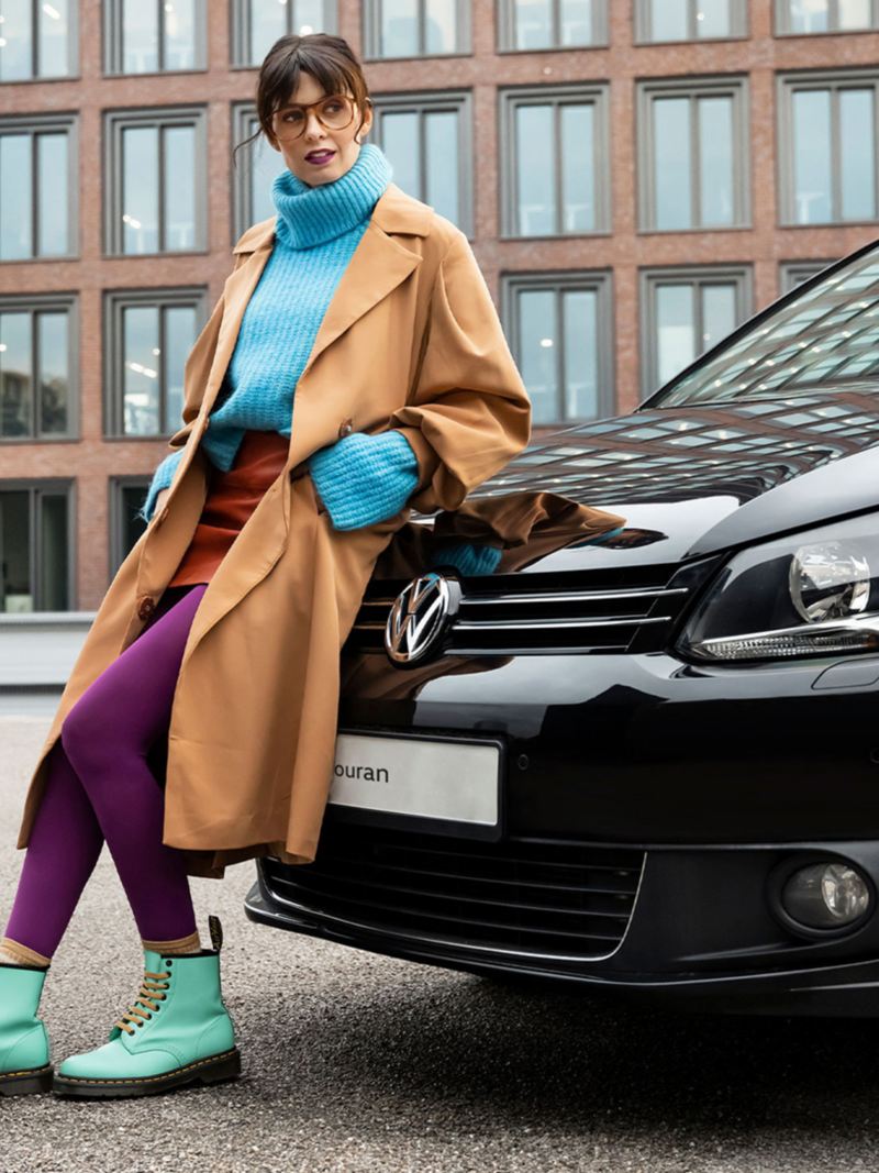 A woman leans against her Touran 1 from Volkswagen