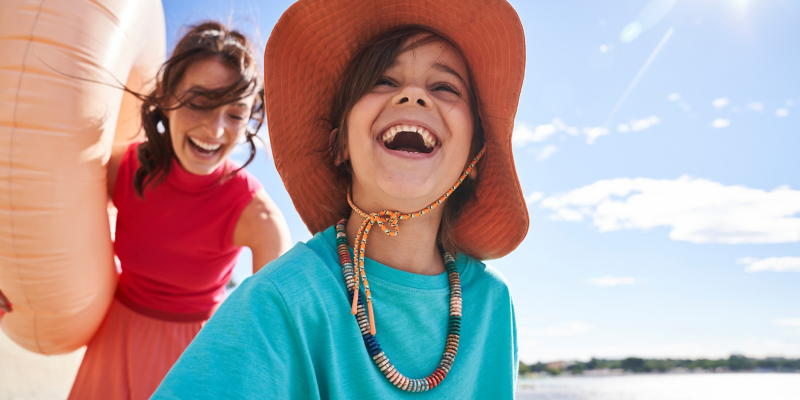 Spaß am Meer – Frau und Kind mit herzlichem Lachen  