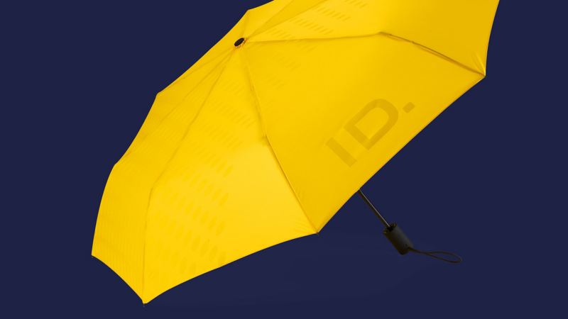 Un paraguas amarillo abierto con la inscripción «ID.» – Accesorios VW