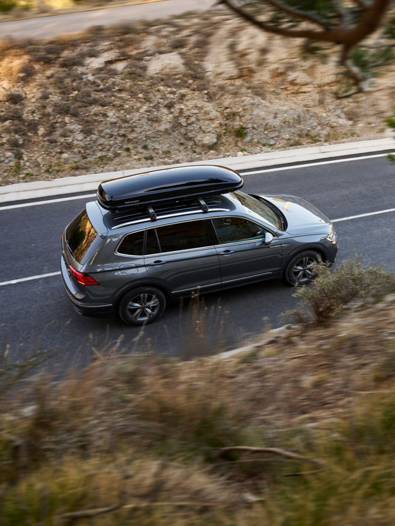VW Tiguan z kufrem dachowym z oferty Akcesoriów VW na wiejskiej drodze