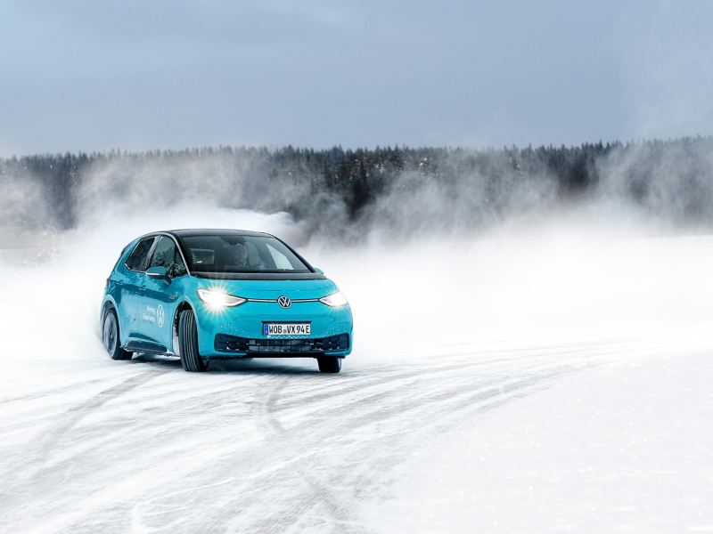 A VW car driving on a road in a wintry landscape