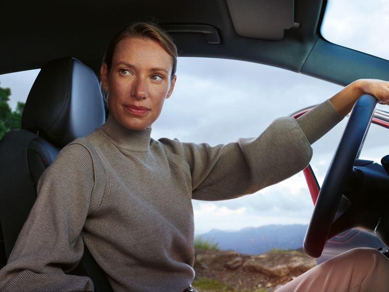 Eine Frau sitzt am Lenkrad eines VW ID.5 GTX und wartet auf den Start ihrer Driving Experience Tour Norwegen