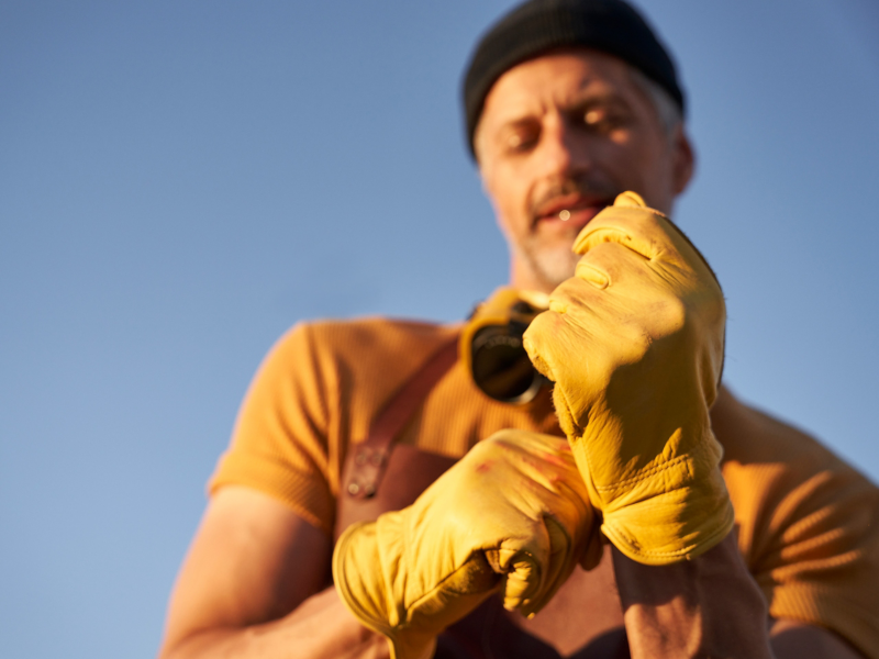 Hobbyhandwerker zieht sich Schutzhandschuhe an