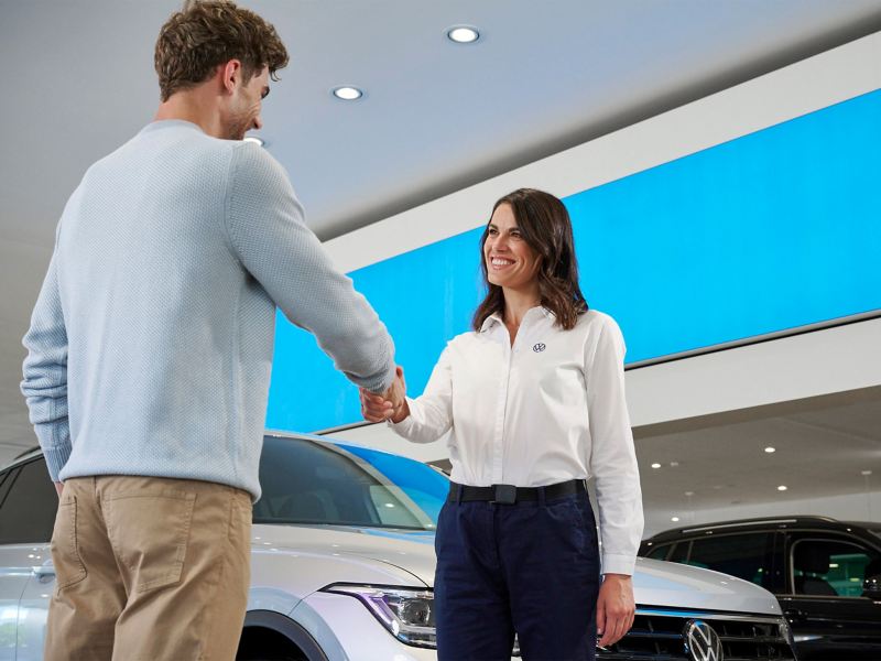 Customer and VW service employee shake hands at the dealership