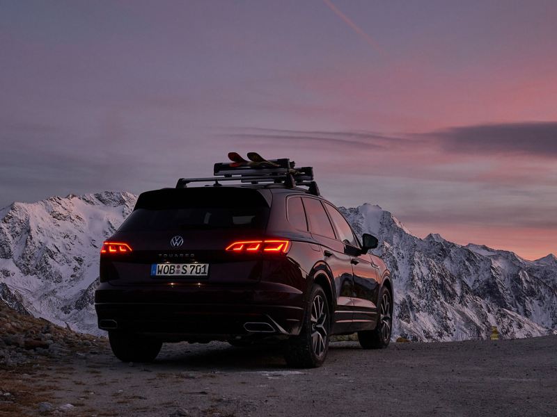 Een VW Touareg voor een bergpanorama in de avond