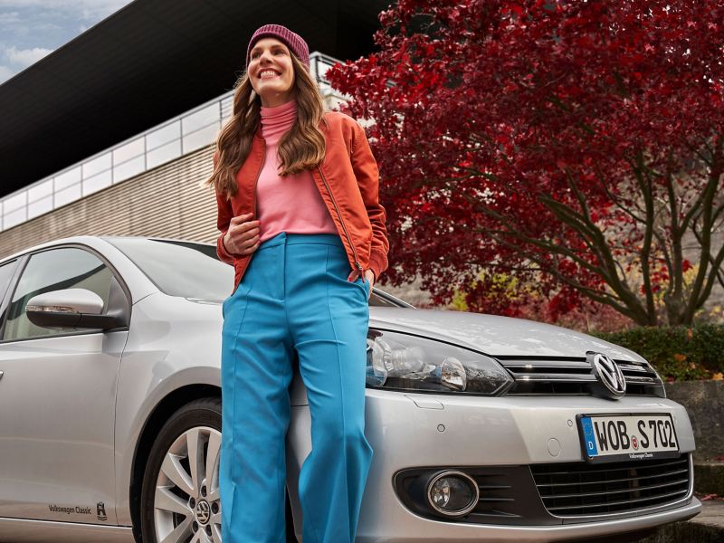 Eine Frau und ihr gebrauchter VW Golf 6 der Kompaktklasse