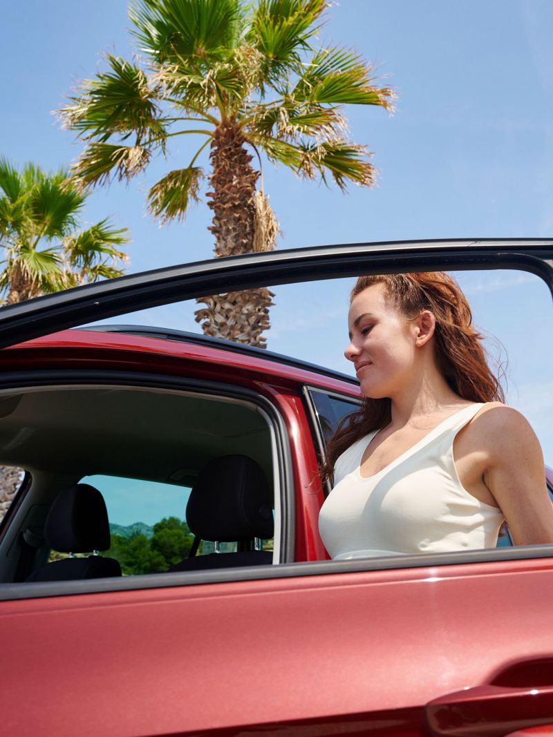 Eine junge Frau steigt in den VW Golf Sportsvan ein