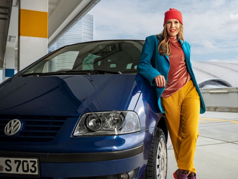 Kobieta opiera się o samochód VW Sharan 1 – starsze minivany